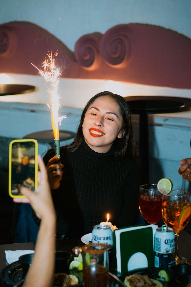Before: 2000s Date Stamp AI filter result: woman celebrating a birthday with a sparkler