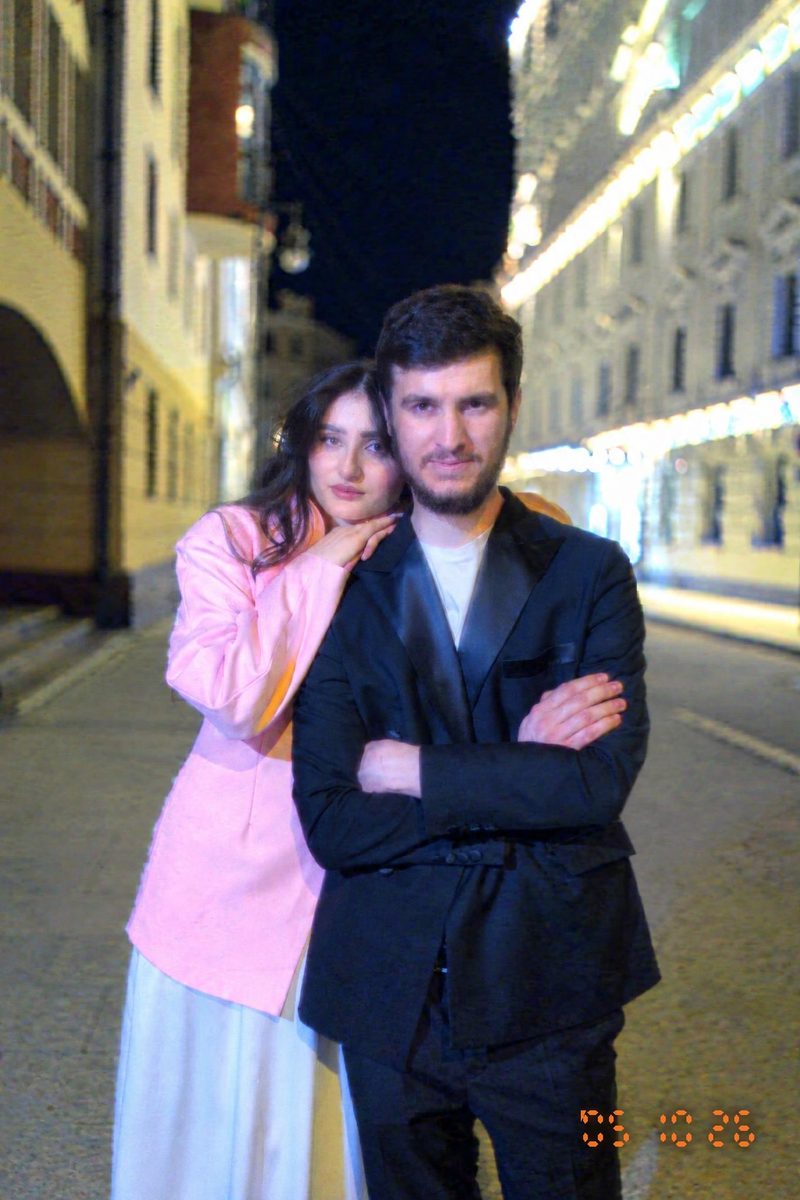 AI-generated: 2000s Date Stamp AI filter result: stylish couple on a city street at night