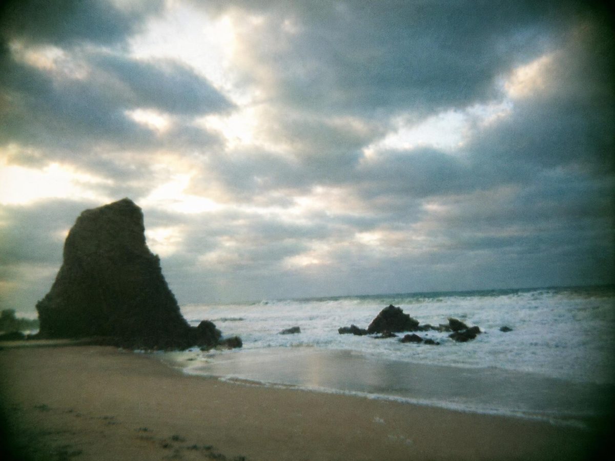 AI-generated: Disposable Camera AI filter result: rocky beach under a cloudy sky