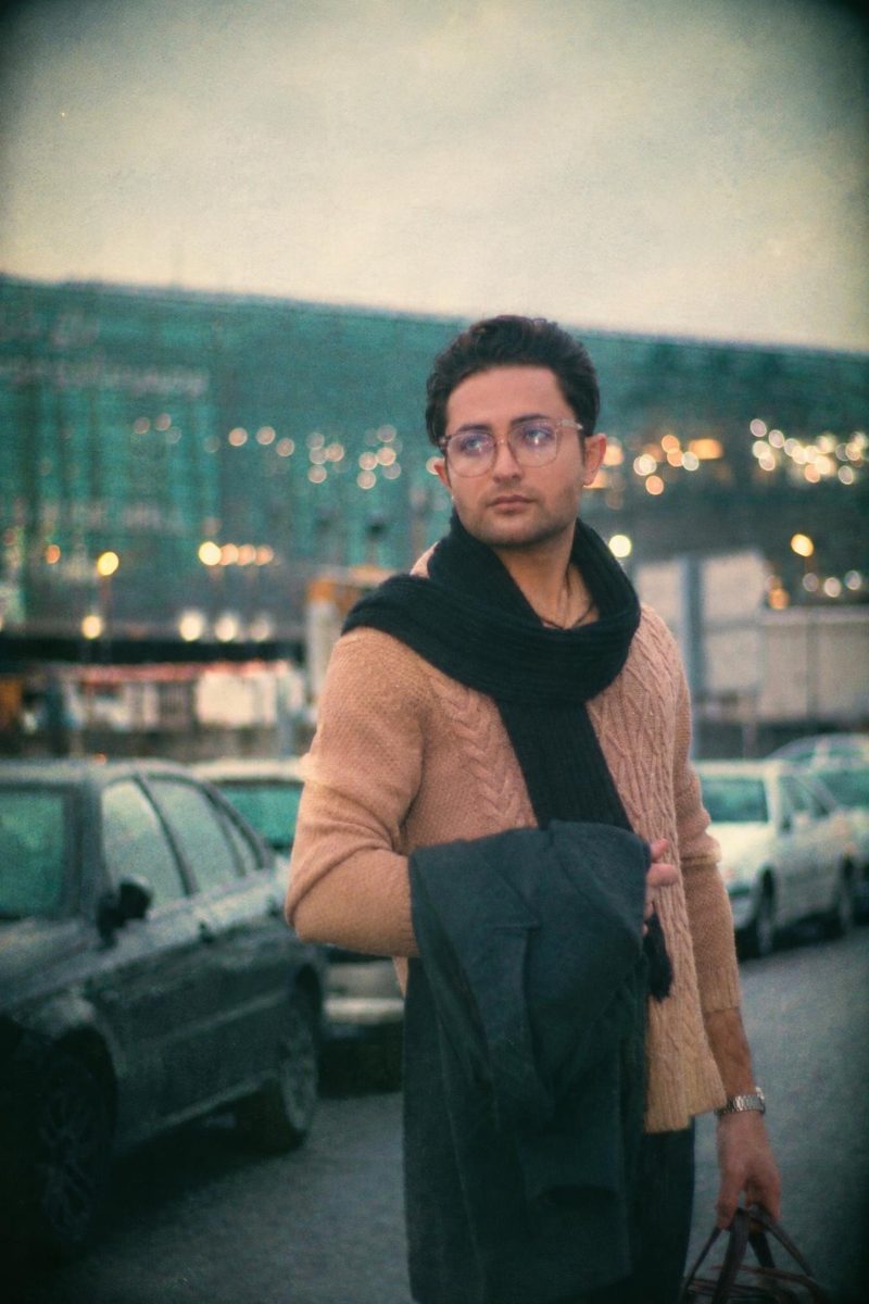 AI-generated: Disposable Camera AI filter result: man in a brown sweater and scarf on a city street