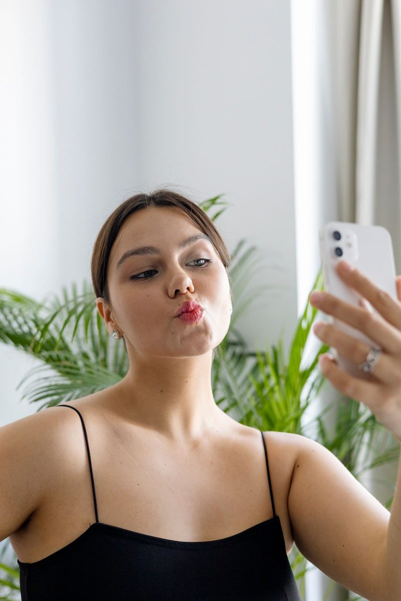 Before: Gold 200 Film AI filter result: woman in a black top taking a mirror selfie