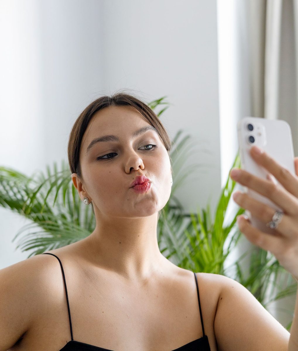 Before: Instant Film Frame AI filter result: woman in a black top taking a mirror selfie