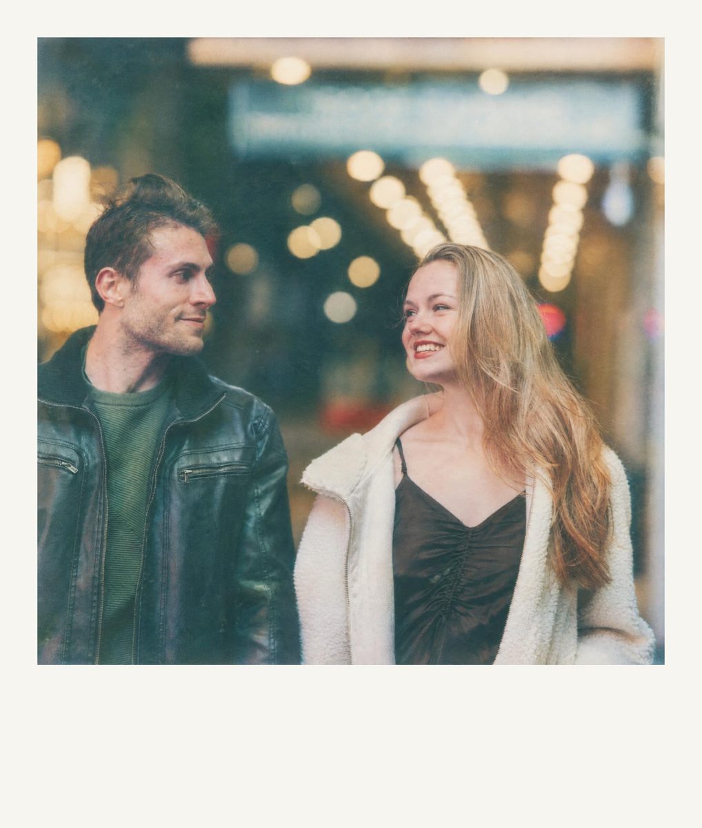 AI-generated: Instant Film Frame AI filter result: smiling couple walking down a street at night