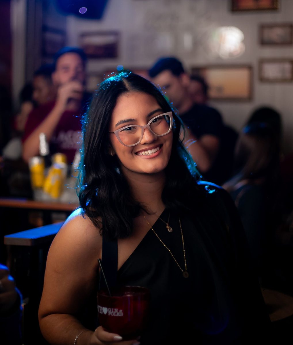 Before: Instant Film Frame AI filter result: smiling woman with a drink on a night out at a bar