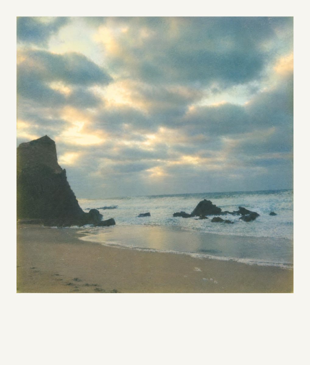 AI-generated: Instant Film Frame AI filter result: rocky beach under a cloudy sky