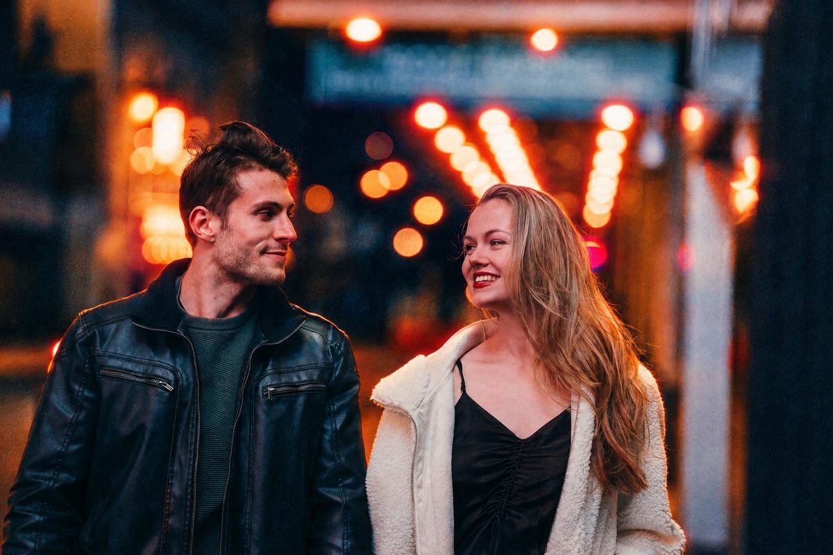 AI-generated: Night Tungsten 800 AI filter result: smiling couple walking down a street at night