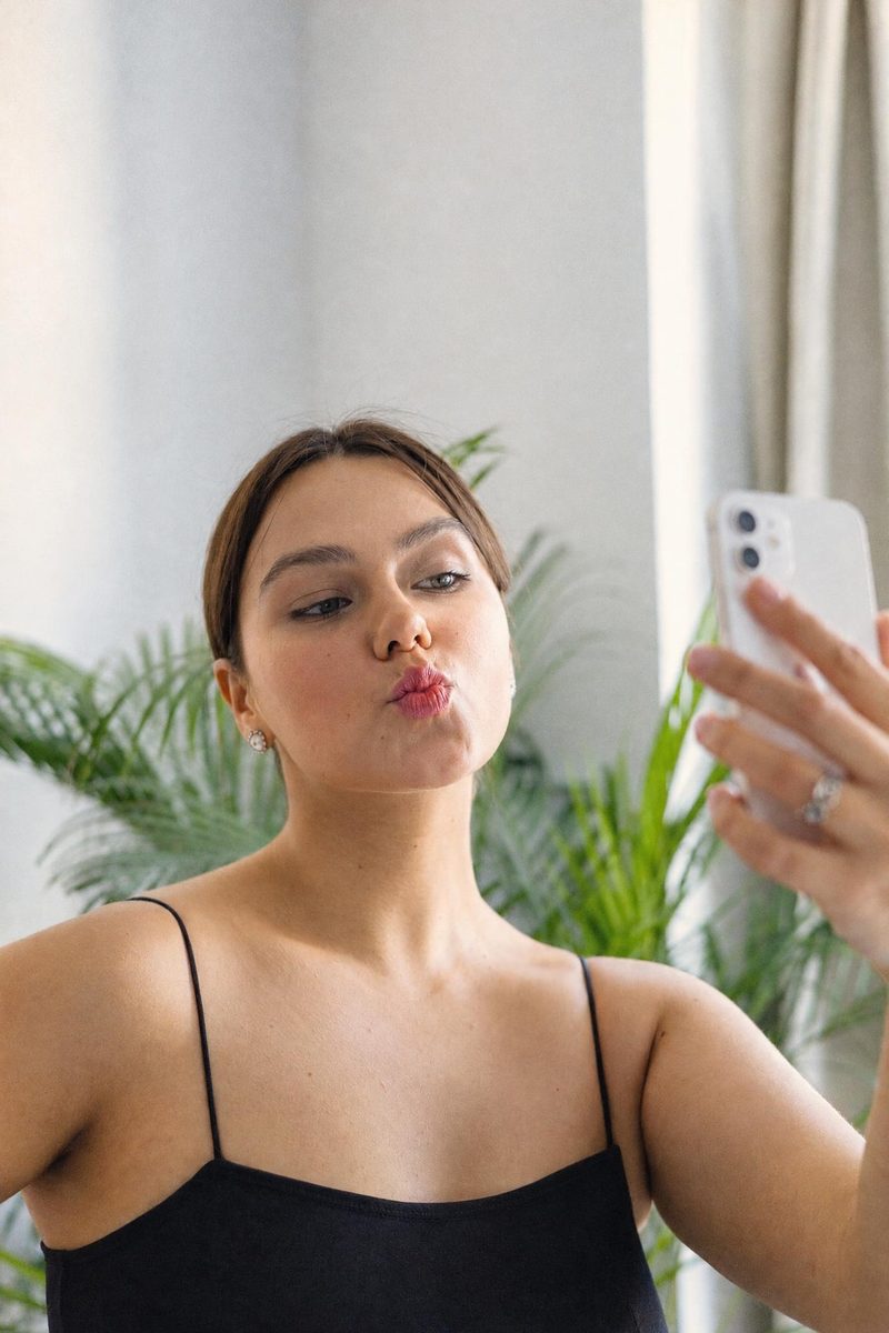 AI-generated: Warm Portrait 400 AI filter result: woman in a black top taking a mirror selfie