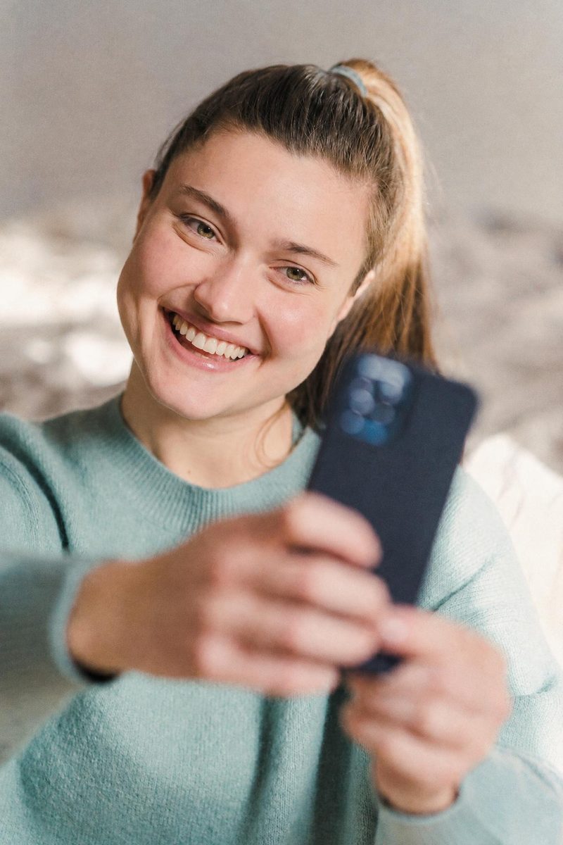 AI-generated: Warm Portrait 400 AI filter result: young woman taking a selfie
