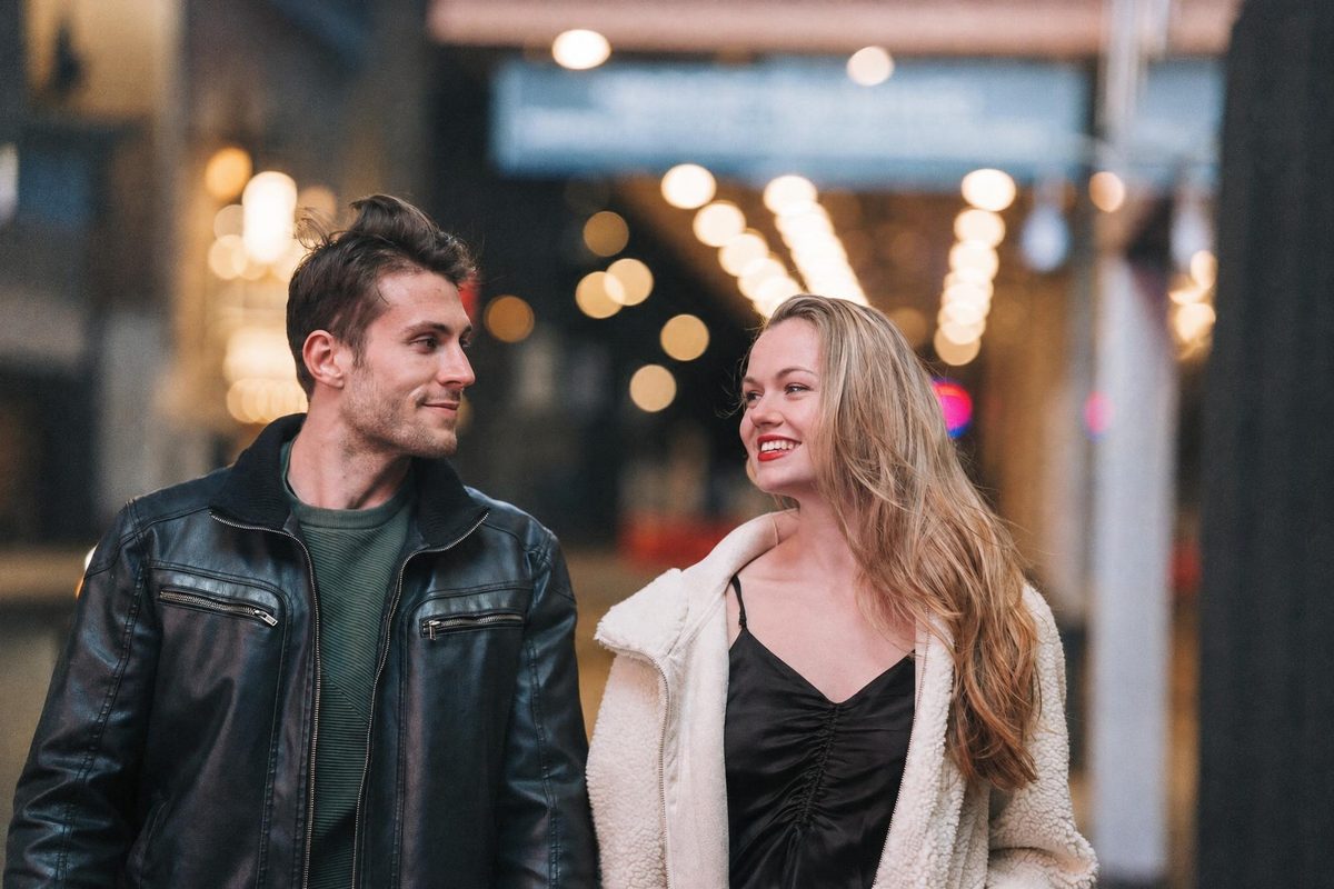 AI-generated: Warm Portrait 400 AI filter result: smiling couple walking down a street at night
