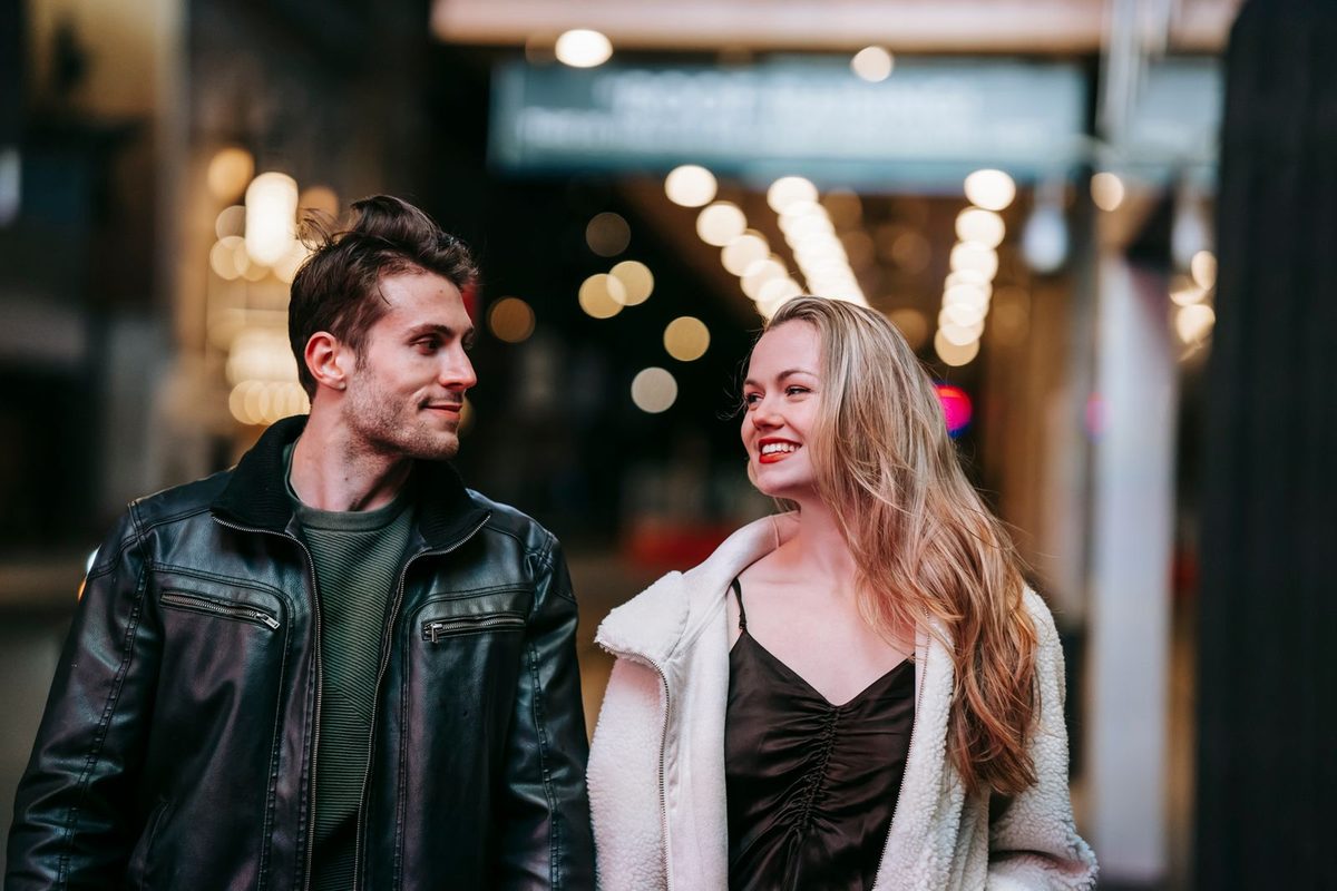 Before: Warm Portrait 400 AI filter result: smiling couple walking down a street at night