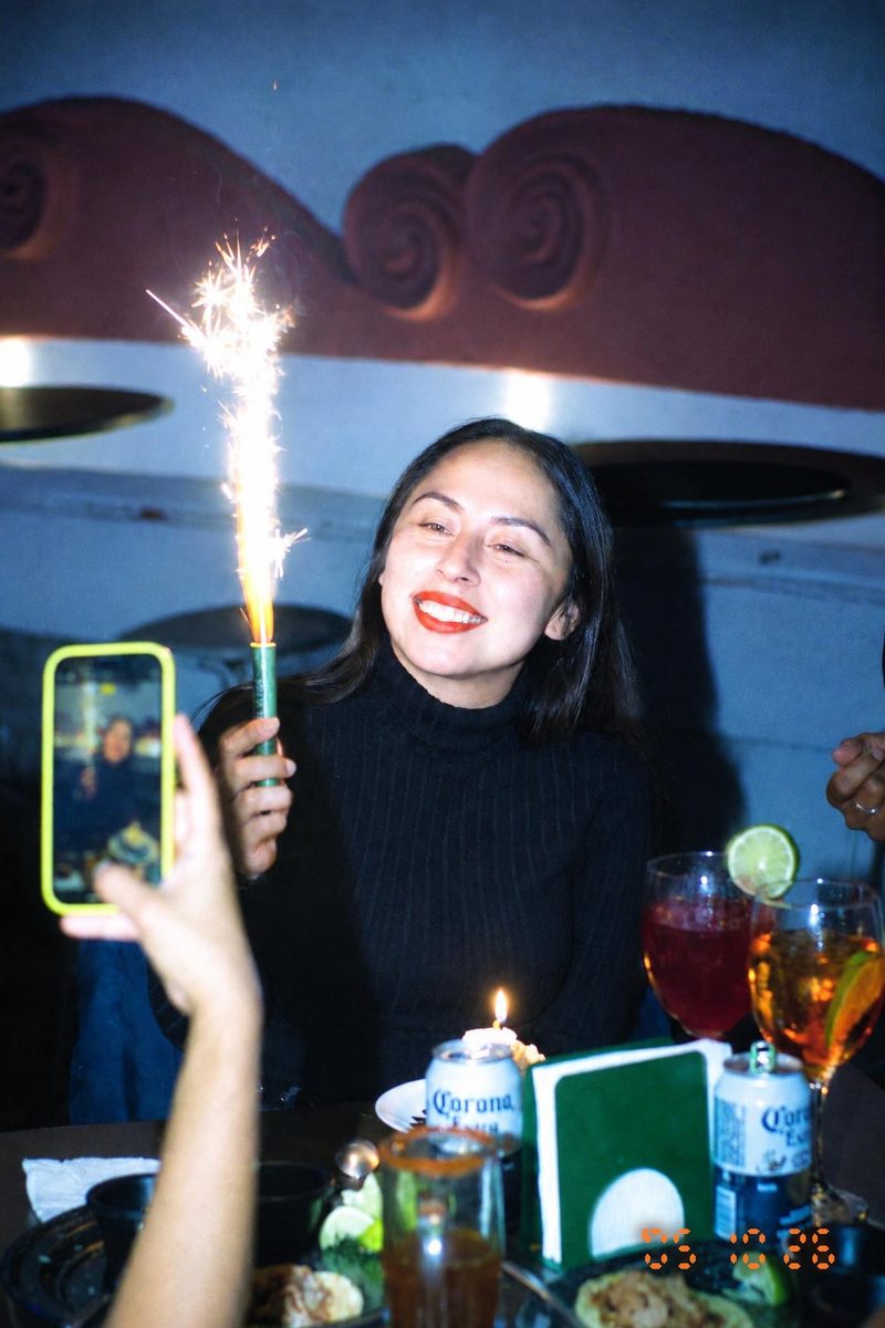 AI-generated: Y2K Compact Digicam AI filter result: woman celebrating a birthday with a sparkler