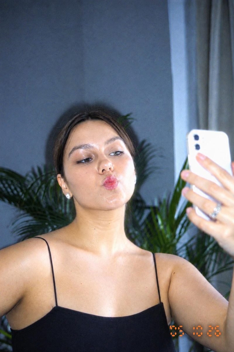 AI-generated: Y2K Compact Digicam AI filter result: woman in a black top taking a mirror selfie